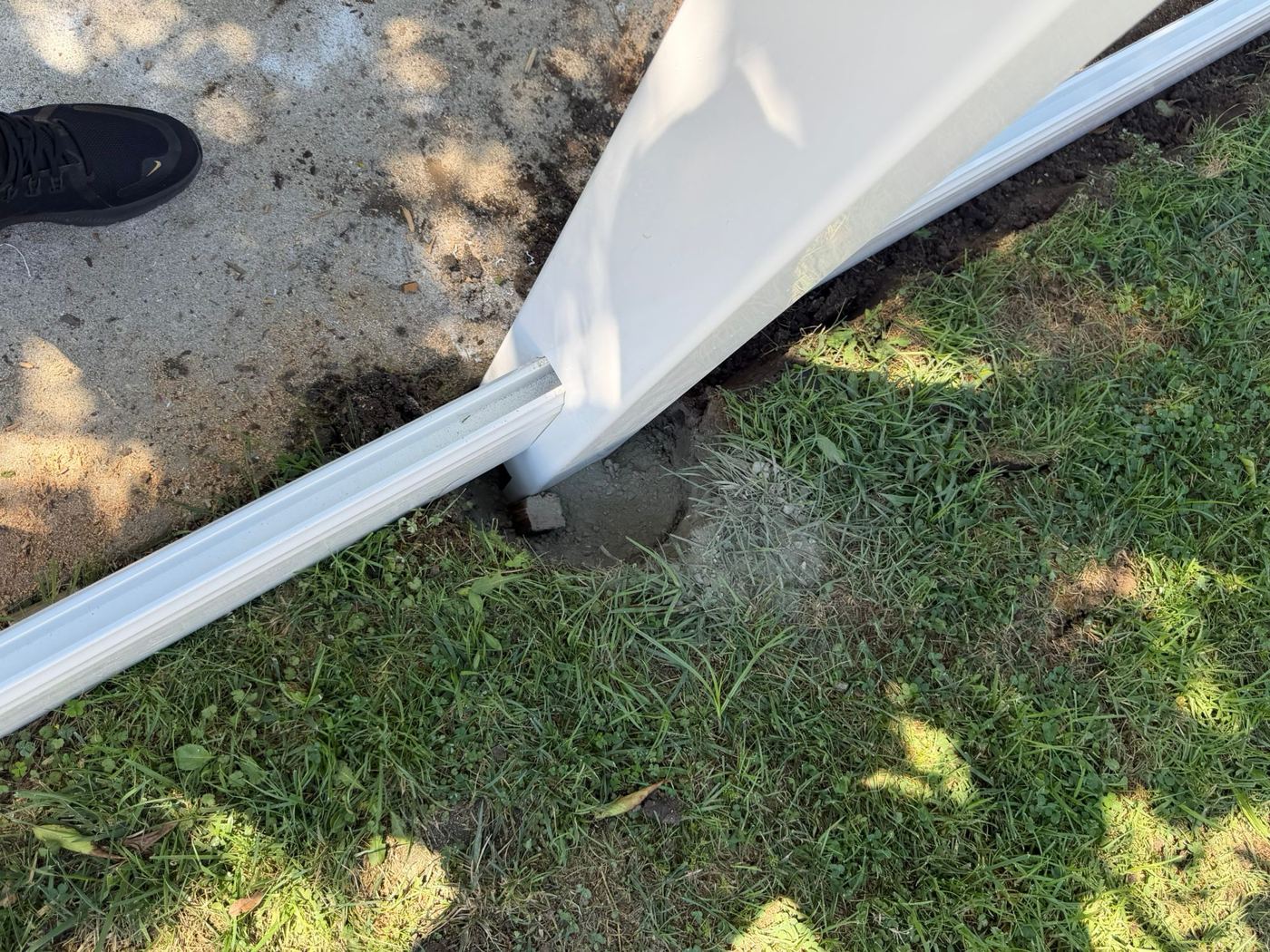 Fence post set in a concrete footing