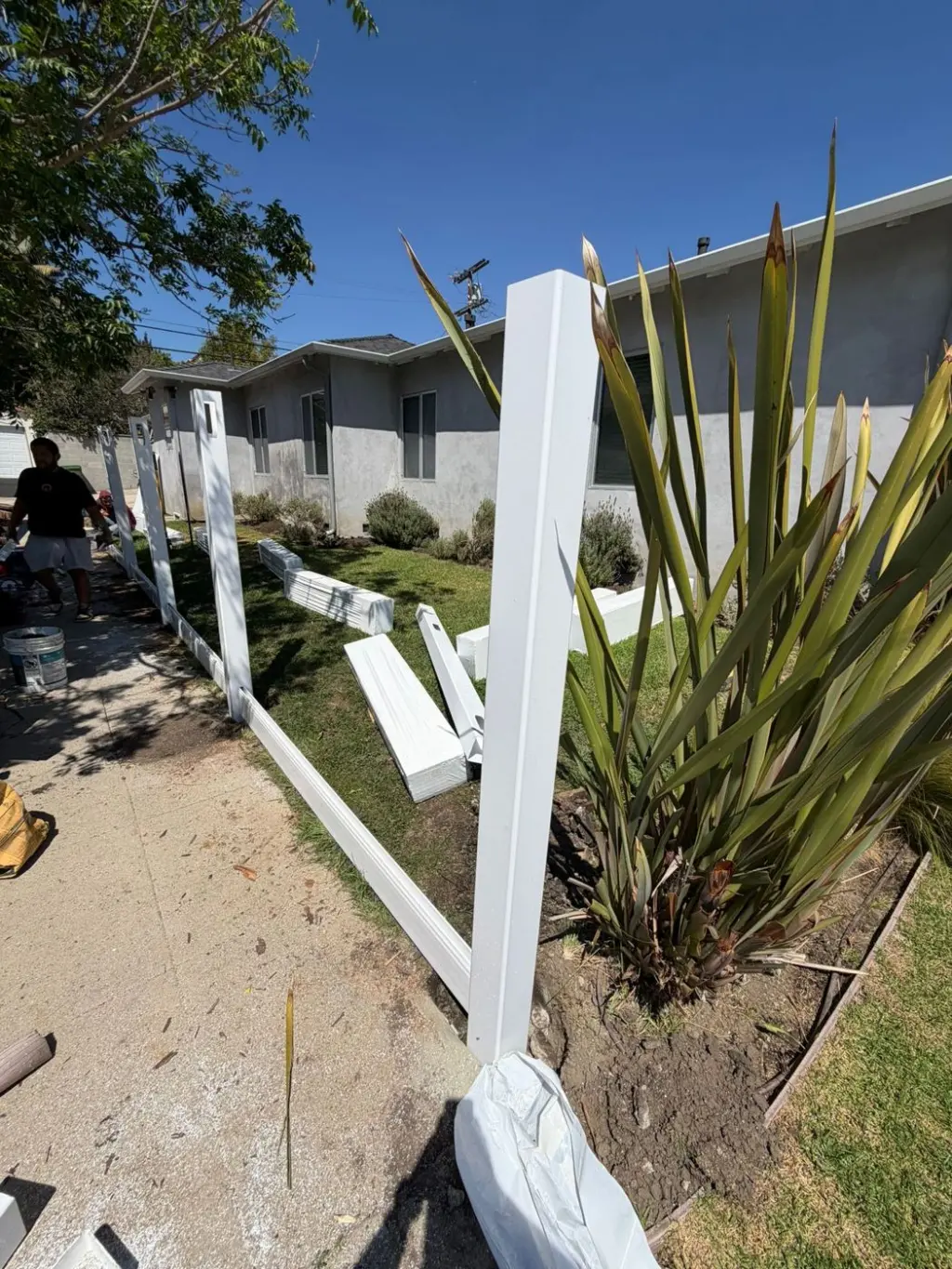 Vinyl fence posts and bottom rails being installed