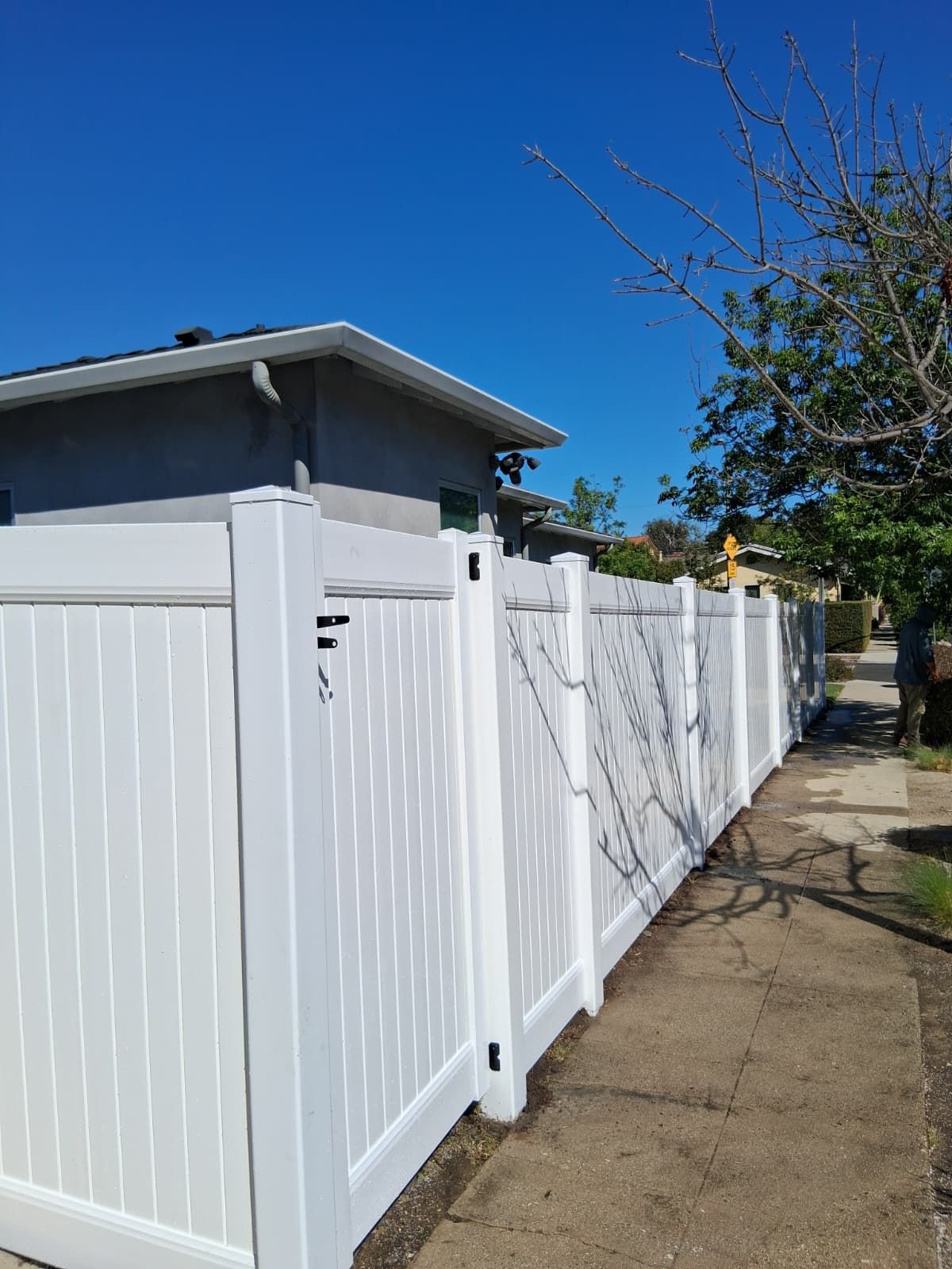 White vinyl fence and gate in a residential neighborhood