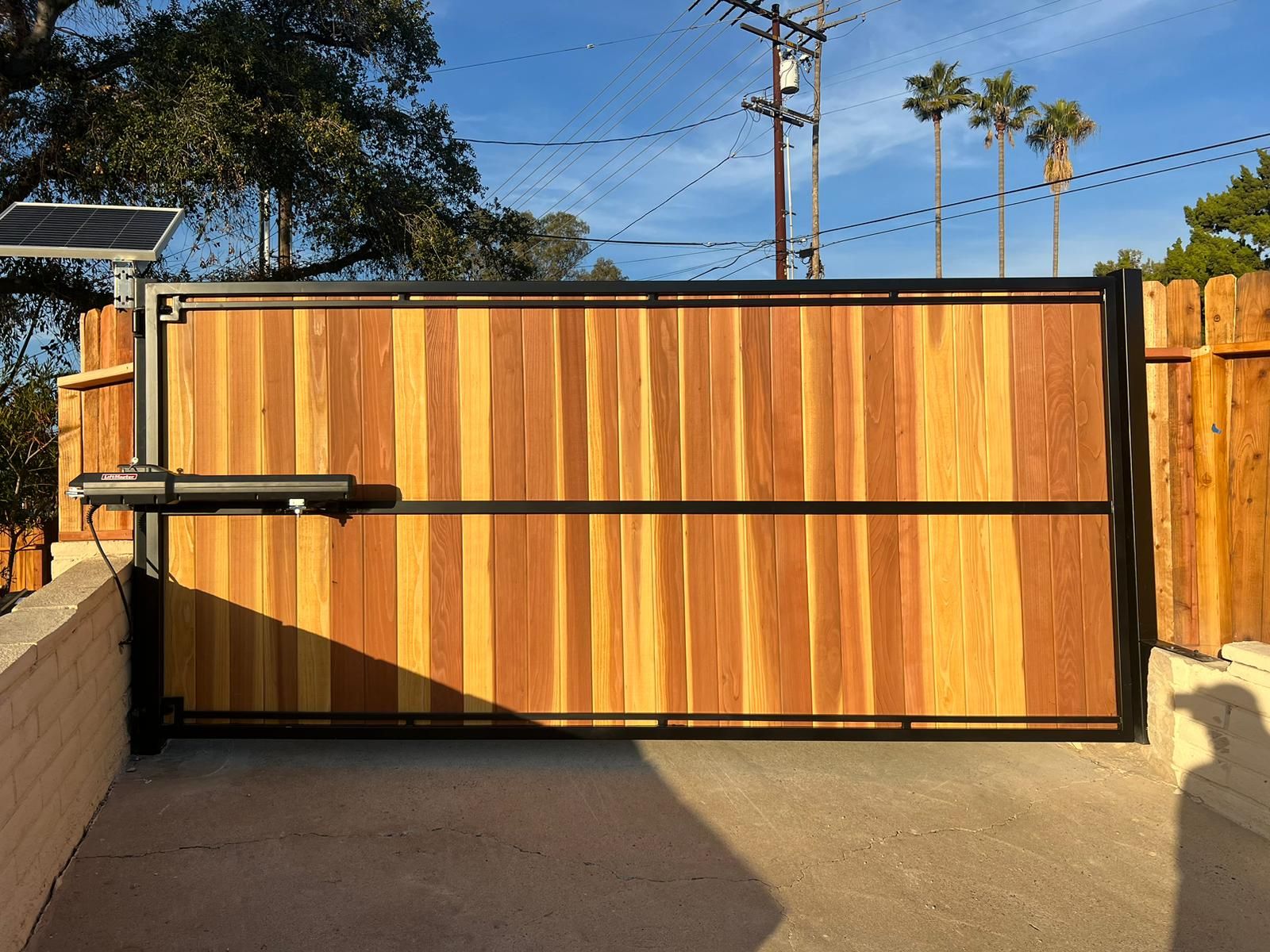 Redwood gate on a steel frame with a solar opener